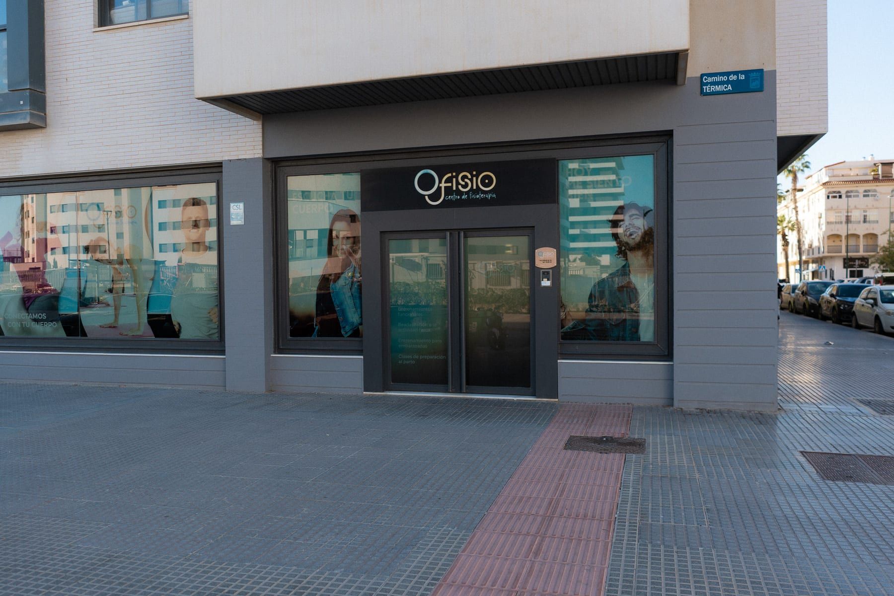 Fachada de Ofisio con la puerta de entrada, el rótulo de la clínica y la placa de la calle
