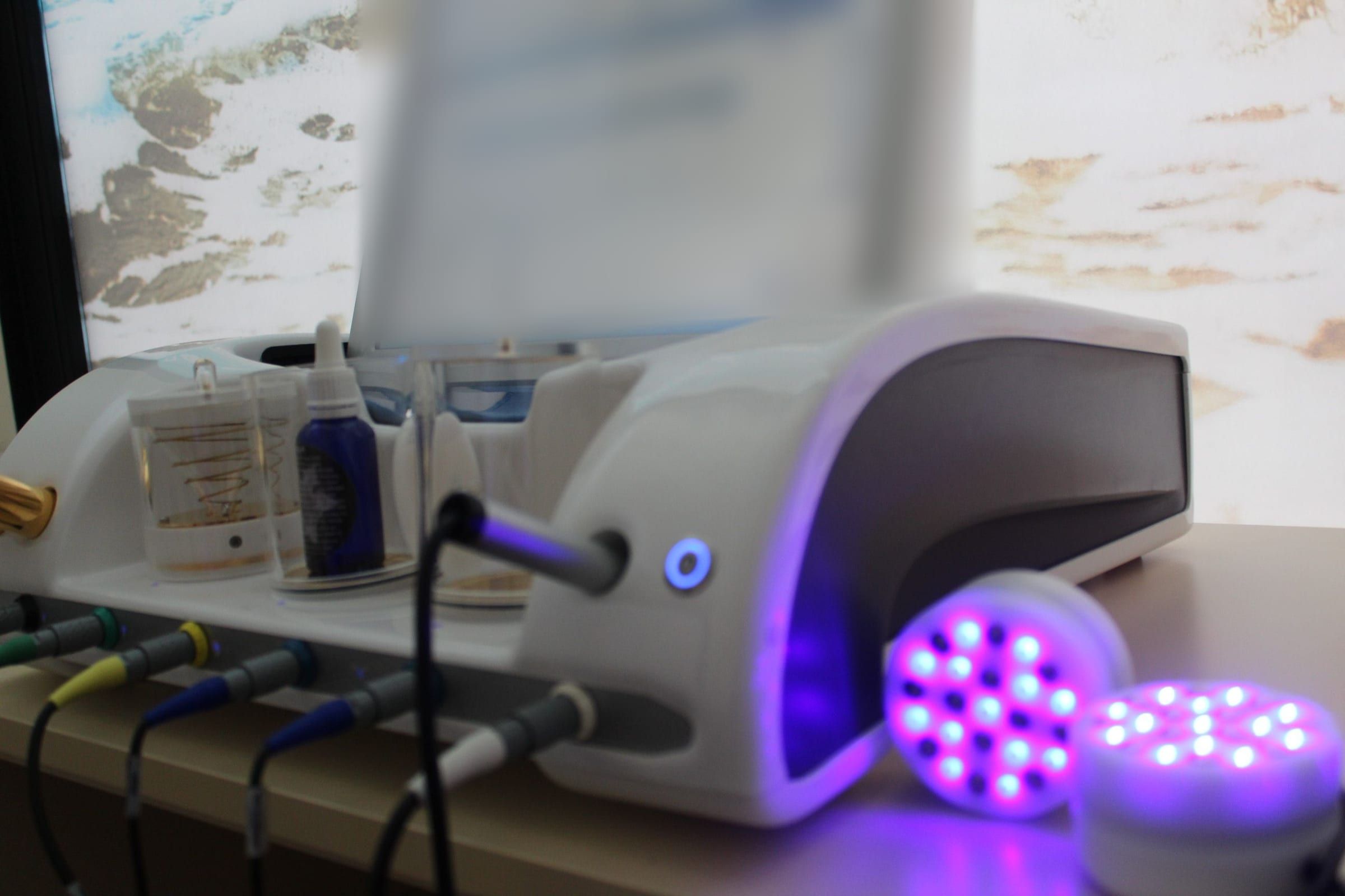 Equipo de biorresonancia Mora con vasos de cristal, cables de colores y dos focos de luz violeta encendidos