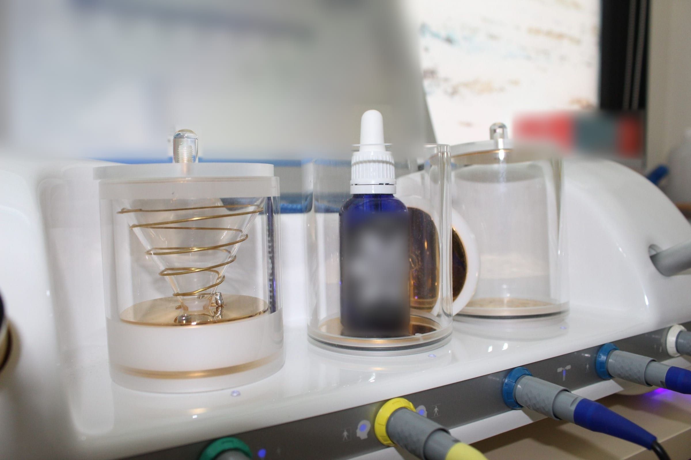 Detalle de los vasos de cristal y las conexiones de colores del equipo de biorresonancia Mora